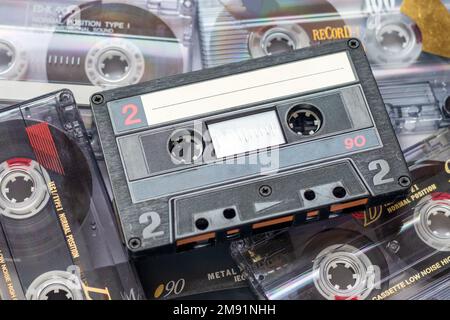 Un nastro per audiocassette su una pila di audiocassette sovrapposte Foto Stock