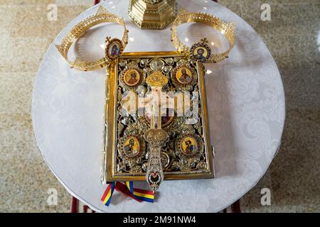 Un crown d'oro su un'antica Sacra Bibbia con copertine preziose d'oro su un tavolo, ripresa dall'alto Foto Stock