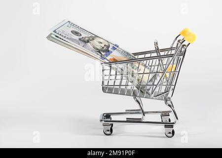Una confezione di dollari in un carrello di ferro allo sfondo bianco Foto Stock
