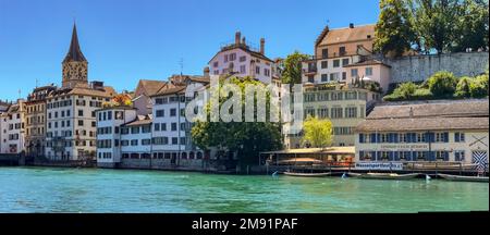 Pittoresca vista delle case sul Schipfe e la Chiesa di San Pietro sulle rive del Limmat a Zurigo, Svizzera Foto Stock