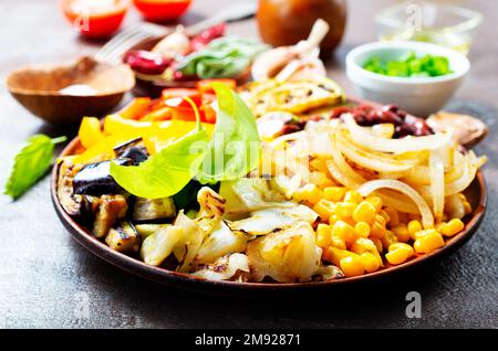 verdure miste fritte su piatto scuro Foto Stock