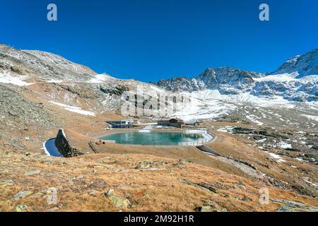 Madritschhuette e il serbatoio d'acqua che si affaccia sulle montagne in un giorno di sole autunno Foto Stock
