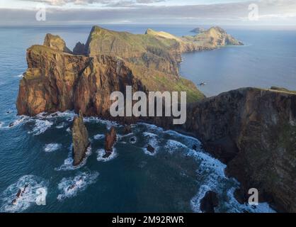 Vista del crinale di montagna circondata da acqua di mare blu sotto il cielo nuvoloso a Madeira Foto Stock