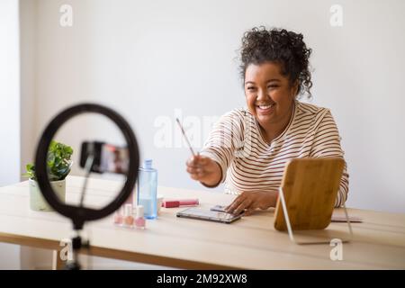 Allegro giovane donna femmina bellezza blogger raccomandare vari prodotti di bellezza Foto Stock