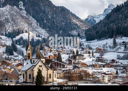 Moena, Italia, gennaio 16th 2023. Fresca neve mattutina nelle Dolomiti dietro la Chiesa di San Vigilio e altri edifici del paese. Foto Stock