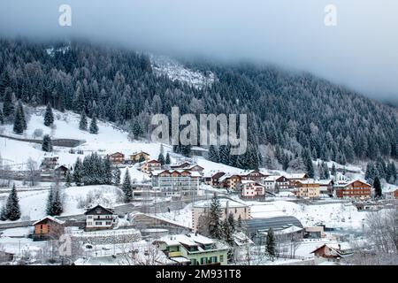 Case e chalet di Moena nelle Dolomiti italiane nel mese di gennaio sotto la neve. Foto Stock