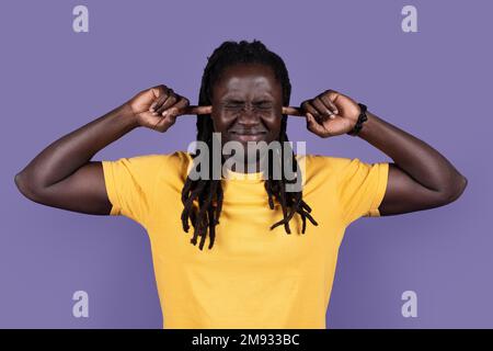 Giovane afro-americano che tappa le orecchie con le dita Foto Stock