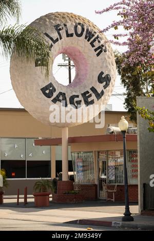 Bellflower, California, USA - 2 maggio 2021: Il sole del pomeriggio splende su un famoso negozio di bagel nel centro di Bellflower. Foto Stock