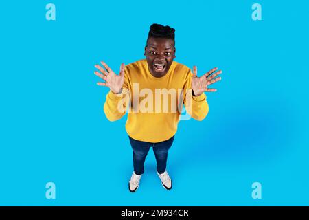 Sopra il colpo del giovane uomo afroamericano che sparge le mani con eccitamento Foto Stock