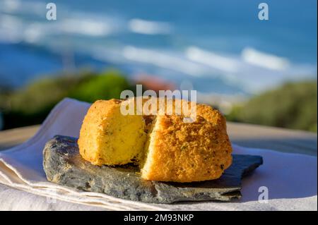 Coccodrillo pastais de bacalhau, spuntini tradizionali portoghesi serviti all'aperto con vista sull'oceano Atlantico blu vicino a Sintra nella zona di Lisbona, P Foto Stock