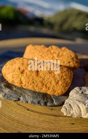 Coccodrillo pastais de bacalhau, spuntini tradizionali portoghesi serviti all'aperto con vista sull'oceano Atlantico blu vicino a Sintra nella zona di Lisbona, P Foto Stock