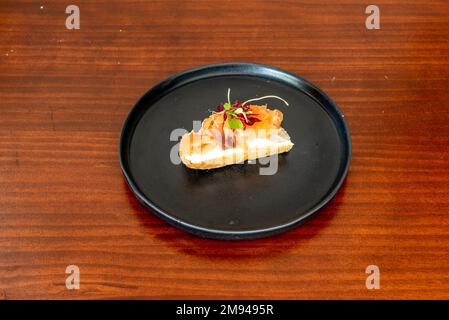 Un delizioso pincho servito in un ristorante spagnolo con formaggio cremoso e salmone norvegese Foto Stock