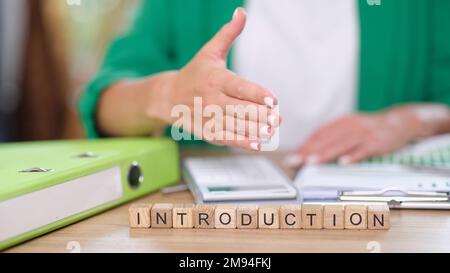 Il manager invita a fare la mano alla scrivania con documenti finanziari e introduzione di lettere sui cubi. Foto Stock