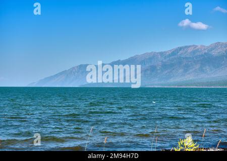 Barguzinsky Bay e le montagne della penisola del Santo naso del lago Baikal nella Repubblica di Buryatia durante il giorno con un sole limpido Foto Stock