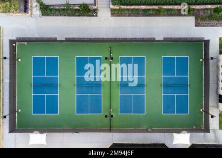 Vista dall'alto, vista aerea di quattro blu pubblico, campi da tennis vuoti, campi da tennis in estate all'aperto. Foto Stock