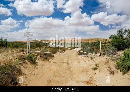 Porta bianca con il segno "Gesù ti ama" in un deserto in Arizona. Erba secca e formazioni di arenaria sotto il cielo azzurro nuvoloso nelle calde giornate estive. Arizona, Stati Uniti Foto Stock