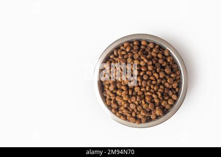 asciugare gli alimenti per animali domestici in un recipiente di metallo isolato su sfondo bianco, spazio per le copie. Cibo per gatti e cani modello. Mucchio di alimenti di animali granulati. Granuli di GO Foto Stock