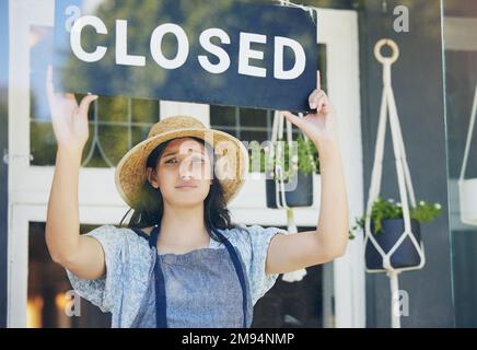 Il momento di rilassarsi è quando non avete tempo. una giovane fiorista femminile che tiene un cartello chiuso sul lavoro. Foto Stock
