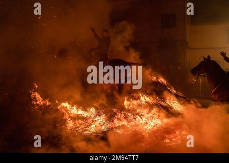 San Bartolome De Pinares, Spagna. 16th Jan, 2023. Un cavaliere attraversa un falò fatto con rami di pino nel villaggio di San Bartolome de Pinares durante la tradizionale festa religiosa di 'Las Luminarias' in onore di San Antonio Abad (Sant'Antonio), santo patrono degli animali celebrato ogni notte del 16 gennaio. I cavalieri partecipano ad una processione con i loro cavalli e asini, attraversando i molteplici falò illuminati sulle strade della Città. (Foto di Guillermo Gutierrez/SOPA Images/Sipa USA) Credit: Sipa USA/Alamy Live News Foto Stock