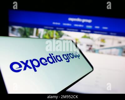 Cellulare con il logo della società di viaggi online americana Expedia Group Inc. Sullo schermo di fronte al sito web aziendale. Messa a fuoco al centro del display del telefono. Foto Stock