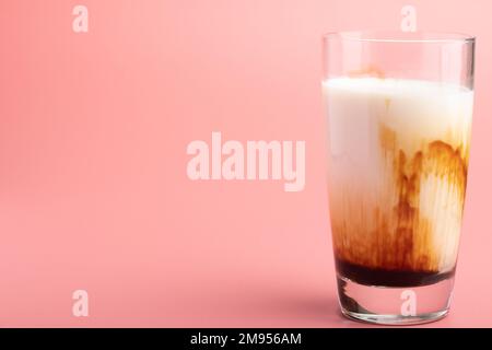 Latte fresco di zucchero di canna in un bicchiere trasparente su sfondo rosa Foto Stock