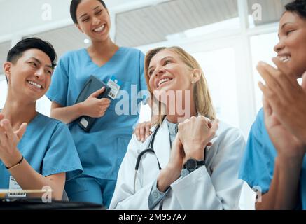 Shes il migliore mentore da cercare. un gruppo di medici che stringe le mani in una riunione sul lavoro. Foto Stock