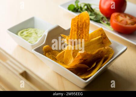 Fiche di banana con guacamole. Il guacamole è un tuffo, una diffusione o un'insalata a base di avocado sviluppata per la prima volta in Messico. Foto Stock