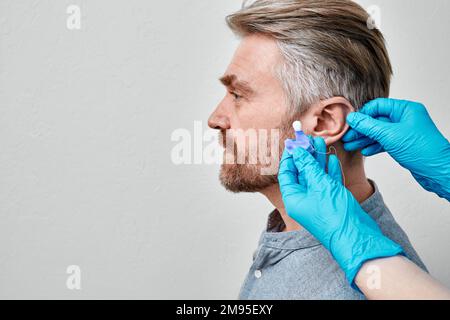 Inserti auricolari personalizzati per la protezione dal rumore. i tappi auricolari individuali per il paziente sono realizzati da un medico in silicone Foto Stock