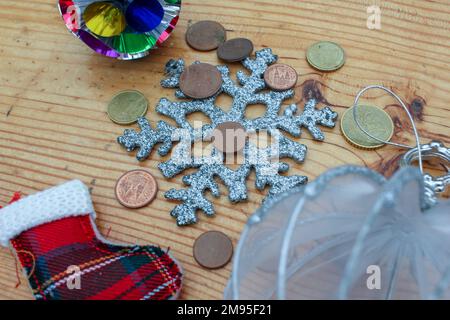 ornamenti natalizi e monete in euro sul tavolo Foto Stock