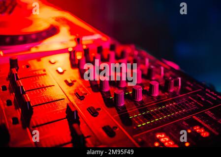 Mixer per la musica nel night club DJ closeup con retroilluminazione rossa Foto Stock