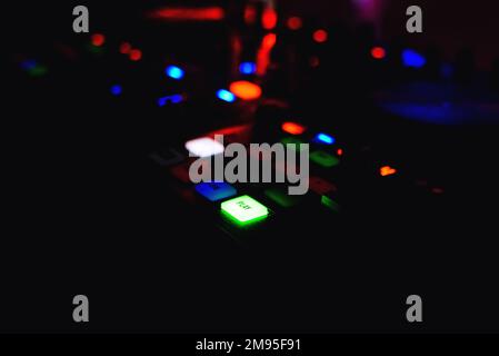Pulsante di riproduzione con retroilluminazione per mixer di musica DJ grande con uno sfondo scuro Foto Stock