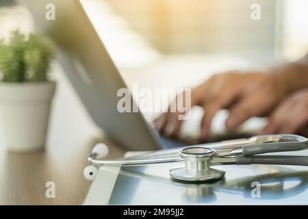 Stetoscopio computer e medico di background utilizzando laptop alla scrivania rete medica su Informatica elettronica medica Foto Stock