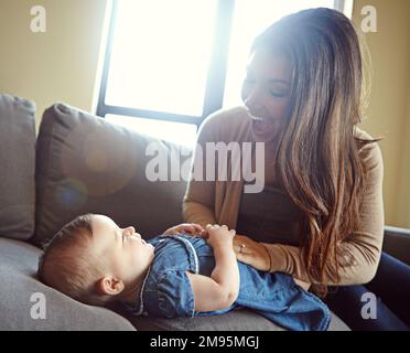 Mamma, legame o ragazza ridere bambino in casa soggiorno o famiglia divano casa in goofy, fumetto o divertente gioco solletico. Sorridere, madre infante e felice Foto Stock