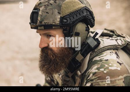 Soldato bearded in uniforme militare che guarda determinato e serio Foto Stock