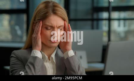 Caucasico di mezza età 40s donna adulta lavoratore ufficio executive stanco malato business donna donna d'affari che lavora con il computer che tiene doloroso Foto Stock