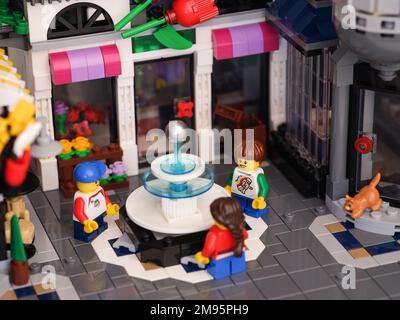 Tambov, Federazione Russa - 07 gennaio 2023 tre minicufigure di Lego bambino in piedi intorno ad una fontana nella piazza della città Foto Stock