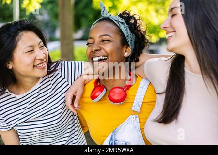 Tre amici multietnici uniti che si divertono a ridere insieme all'aperto Foto Stock