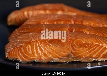 Bistecche di salmone affumicato in primo piano su tavola di legno Foto Stock