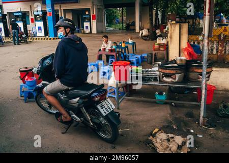 MUI NE, VIETNAM - CIRCA 2017 MARZO: Vietnamita vicino alla stazione di servizio sul marciapiede Foto Stock