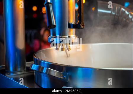 Macchina per preparare dolci churros dessert spagnolo bastoncini sul mercato notturno di Natale a Bilbao, Spagna Foto Stock
