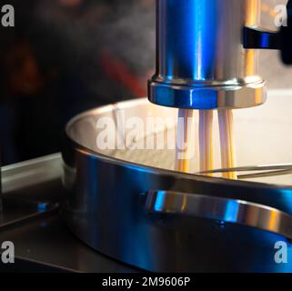Macchina per preparare dolci churros dessert spagnolo bastoncini sul mercato notturno di Natale a Bilbao, Spagna Foto Stock