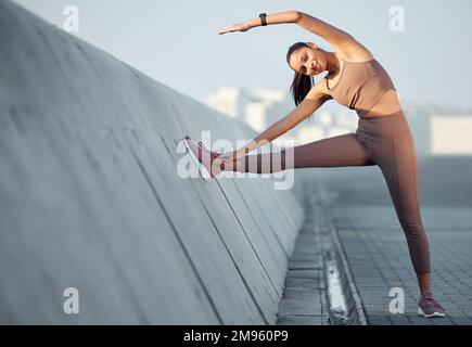 Sono riuscito a scaldare ogni parte del mio corpo. Ritratto di una giovane donna sportiva che si allunga mentre si esercita all'aperto. Foto Stock