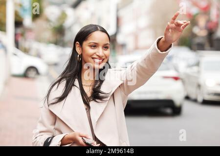 Pronto per tornare a casa. una giovane donna che salutava un taxi dopo lo shopping. Foto Stock