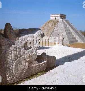 CHICHEN ITZA, YUKATAN. Una testa di serpente al tempio dei guerrieri. Sullo sfondo si trova El Castillo, conosciuto anche come la piramide o tempio di Kukulcan. Foto Stock