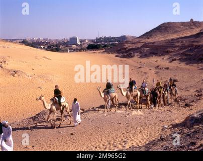 Turisti su cammelli, a cavallo fino alla St. Monastero di Simeon Aswan - Egitto. Foto Stock