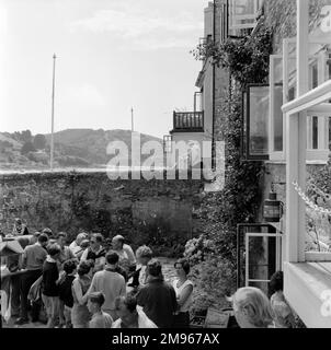 Sorseggiate un drink nel giardino di un pub o nell'area salotto esterna del bar dell'Hotel a Salcombe, Devon. Fotografia di Norman Synge Waller Budd Foto Stock