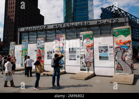 I turisti vedono alcuni resti del Muro di Berlino, in mostra nella Potsdamer Platz, Berlino, Germania. Foto Stock