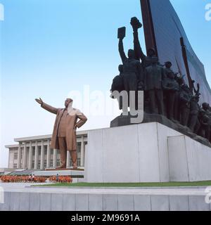 Una statua gigante di Kim il Sung (1912-1994), leader comunista della Corea del Nord, con una rappresentazione di contadini e operai rivoluzionari sulla destra, conosciuto come il Mansudae Grand Monument, situato a Mansu Hill, Pyongyang, capitale della Corea del Nord. La statua è alta 20 metri ed è stata costruita nel 1972 per commemorare il 60th° compleanno del leader. Kim il Sung guidò la Corea del Nord dalla sua fondazione nel 1948 fino alla sua morte, prima come primo Ministro e poi come Presidente. Secondo la leggenda, originariamente la statua era alta 40 metri, ma la modestia di Kim il Sung la richiedeva di essere più piccola. Foto Stock