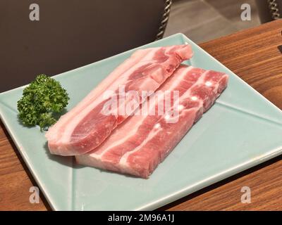 Grigliare carne di maiale pancia su una rete rotonda di ferro barbecue nel ristorante per mangiare, fresco delizioso cibo cucina stile di vita. Foto Stock