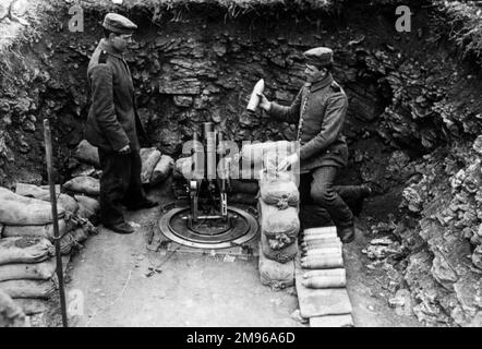 Due soldati che caricano un mortaio da una trincea durante la prima guerra mondiale. Foto Stock